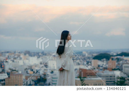 一位日本女性站在城市景觀前，背景是城市風景。 134840121