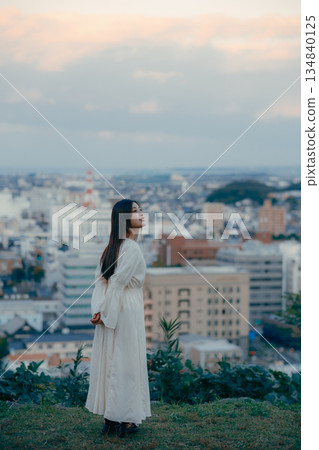 A Japanese woman standing with the cityscape in the background 134840125