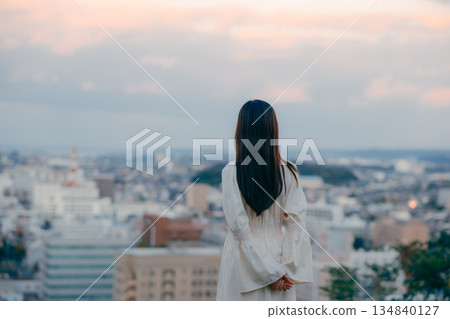 A Japanese woman standing with the cityscape in the background 134840127