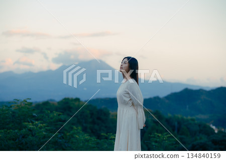 一位日本女性站在山前,背景是一座山。 一位日本女性站在山前,背景是一座山。 134840159