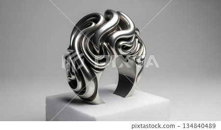 Intricate Silver Ring with Swirling Design on a White Surface Against a White Background Reflecting Light and Texture Intricate Silver Ring with Swirling Design on a White Surface Against a White Background Reflecting Light and Texture 134840489