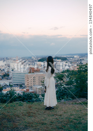 一位女子在俯瞰城市的山丘上提著燈籠 134840497