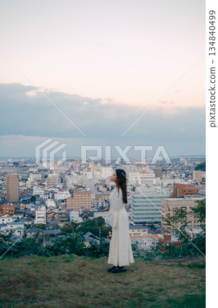 一位女子在俯瞰城市的山丘上提著燈籠 134840499