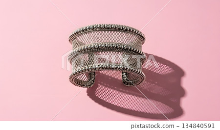 Silver Cuff Bracelet On Pink Surface With Dramatic Shadow And Studio Lighting 134840591