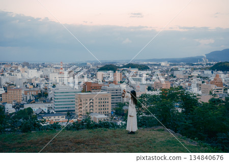 一位女子在俯瞰城市的山丘上提著燈籠 134840676
