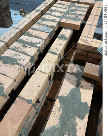 Brickwork of a heating stove bench. Smoke channels and ceiling are visible. Brickwork of a heating stove bench. Smoke channels and ceiling are visible. 134840685