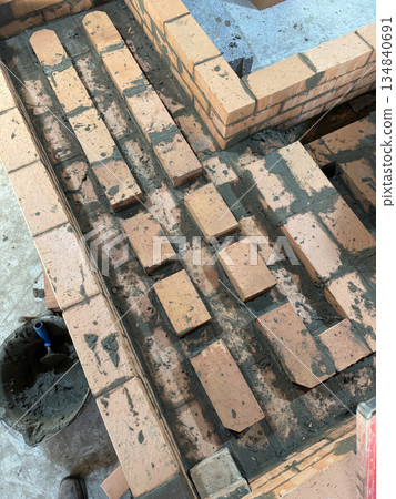 Smoke channels of a stove bench laid with brick. Stove construction. High-Angle Shot. Smoke channels of a stove bench laid with brick. Stove construction. High-Angle Shot. 134840691