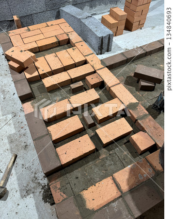 Fresh brickwork of a stove bench. Smoke channels laid with brick. 134840693