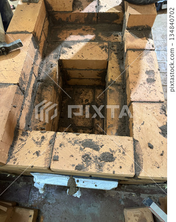 Fresh brickwork of the ash pit and firebox of a heating stove. 134840702
