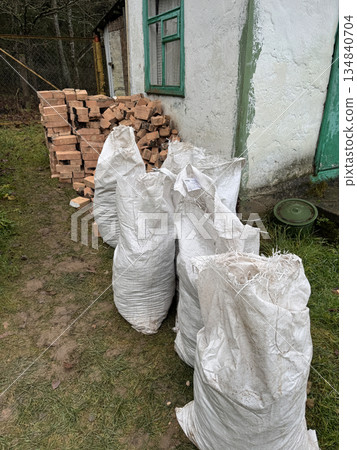Old and broken bricks after dismantling a heating stove. Construction debris in bags. 134840704