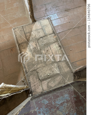 Brick base of an old heating stove between interior partitions. High-Angle Shot.  134840706