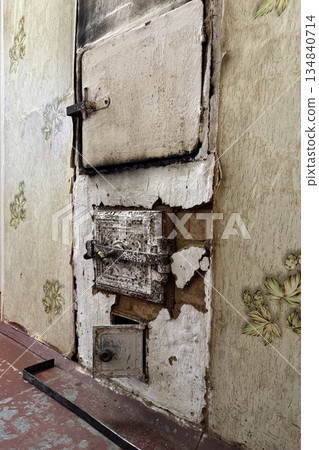 Old heating stove whitewashed with lime. Firebox, oven, and ash pit are visible. Old heating stove whitewashed with lime. Firebox, oven, and ash pit are visible. 134840714