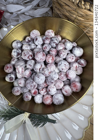 Cranberries in sugar. In a golden cup. Shot from above. 134840722