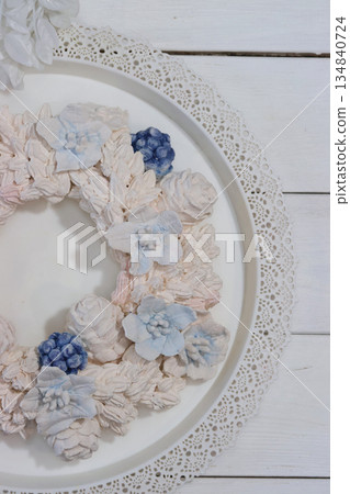 Marshmallow wreath. Wreath made of marshmallow flowers. On a tray. Half of the wreath Marshmallow wreath. Wreath made of marshmallow flowers. On a tray. Half of the wreath 134840724