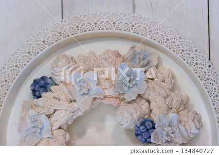 Marshmallow wreath. Wreath made of marshmallow flowers. Shot from above, half of the wreath close-up. Marshmallow wreath. Wreath made of marshmallow flowers. Shot from above, half of the wreath close-up. 134840727