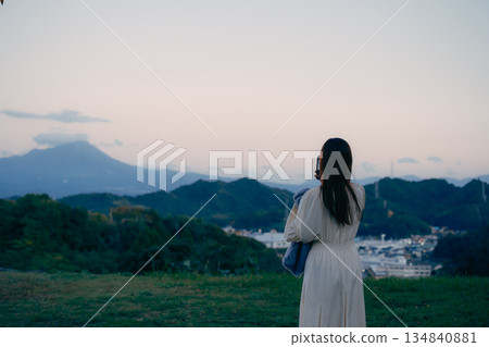 A Japanese woman taking a photo of the mountain scenery with her smartphone A Japanese woman taking a photo of the mountain scenery with her smartphone 134840881