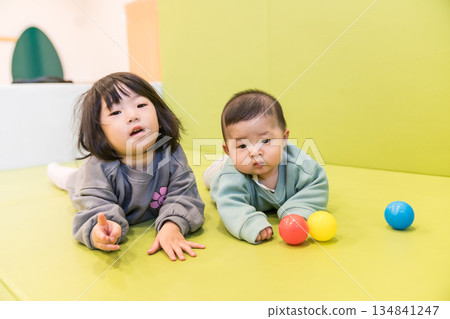 A young Japanese brother and sister playing in the kids' room of an apartment building 134841247