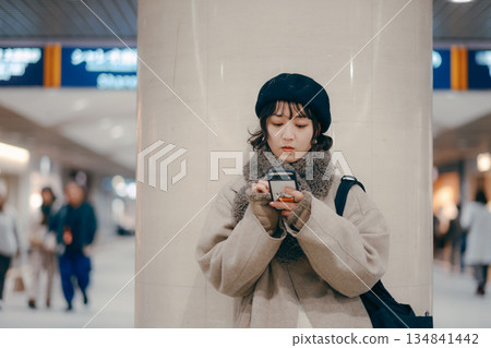 A woman in her 30s using a smartphone while waiting for an appointment A woman in her 30s using a smartphone while waiting for an appointment 134841442