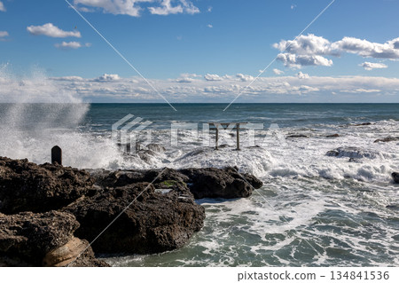 The Kamiiso torii gate and white clouds shining against the backlight of rough waves [Oarai Coast, Ibaraki Prefecture] 134841536