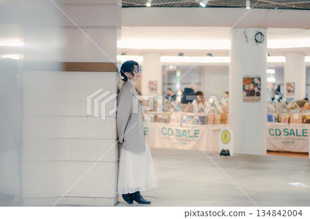 一位三十多歲的女性在等待預約時停了下來 一位三十多歲的女性在等待預約時停了下來 134842004