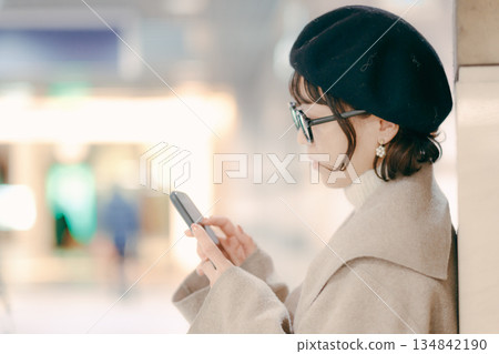 A woman in her 30s checking her smartphone 134842190