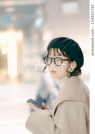 一位三十多歲的女性正在查看她的智慧型手機 一位三十多歲的女性正在查看她的智慧型手機 134842192