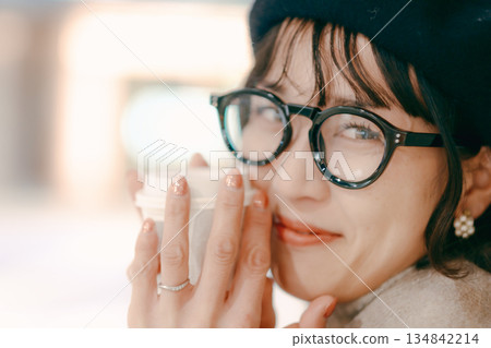 Portrait of a smiling woman in her 30s holding a coffee cup 134842214