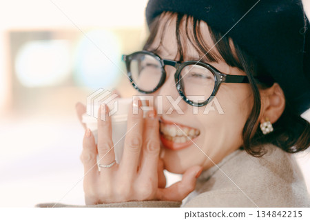Portrait of a smiling woman in her 30s holding a coffee cup 134842215