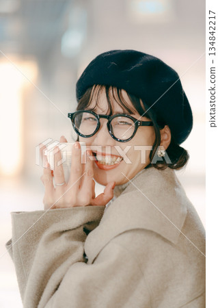 一位三十多歲、微笑的女子手捧咖啡杯的肖像 134842217
