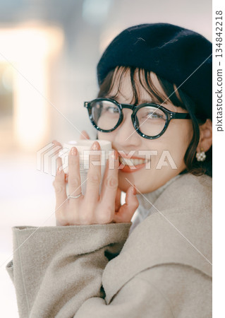 Portrait of a smiling woman in her 30s holding a coffee cup 134842218
