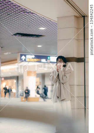 Full-body portrait of a woman in her 30s drinking coffee while waiting 134842245