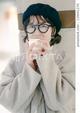 Portrait of a smiling woman in her 30s holding a coffee cup 134842270