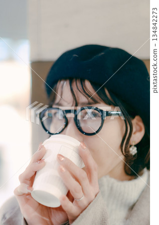 一位三十多歲、微笑的女子手捧咖啡杯的肖像 134842273
