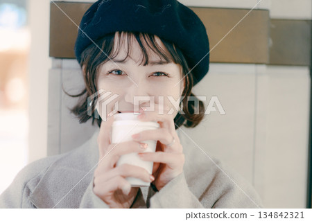 Close-up portrait of a woman in her 30s waiting while drinking coffee Close-up portrait of a woman in her 30s waiting while drinking coffee 134842321