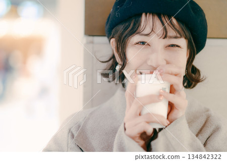 Close-up portrait of a woman in her 30s waiting while drinking coffee Close-up portrait of a woman in her 30s waiting while drinking coffee 134842322
