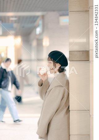 Close-up portrait of a woman in her 30s waiting while drinking coffee 134842331