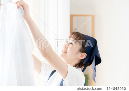 一位女傭正在晾衣物。 134842930