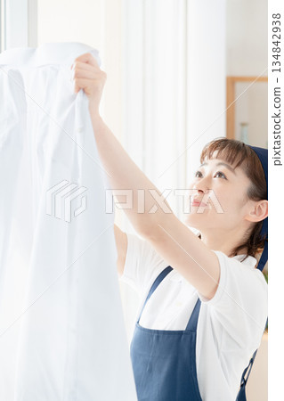 一位女傭正在晾衣物。 134842938