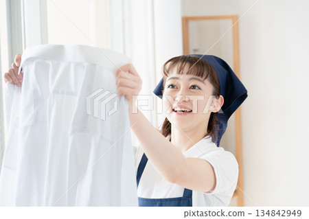 一位女傭正在晾衣物。 134842949