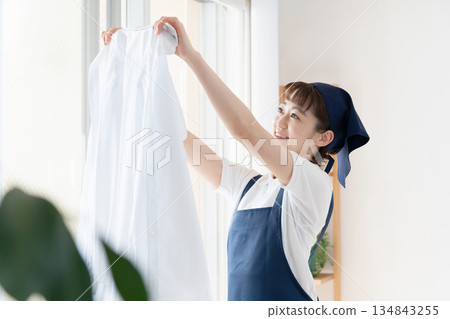 一位女傭正在晾衣物。 134843255
