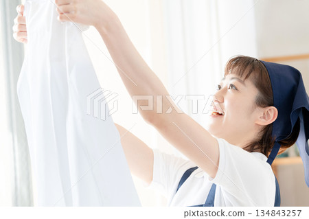 一位女傭正在晾衣物。 134843257