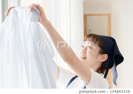 一位女傭正在晾衣物。 134843258