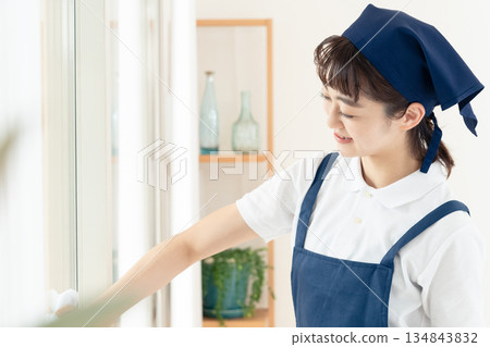 A housekeeping woman cleaning windows 134843832