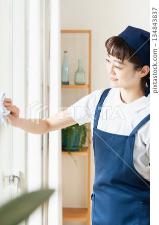 A housekeeping woman cleaning windows A housekeeping woman cleaning windows 134843837
