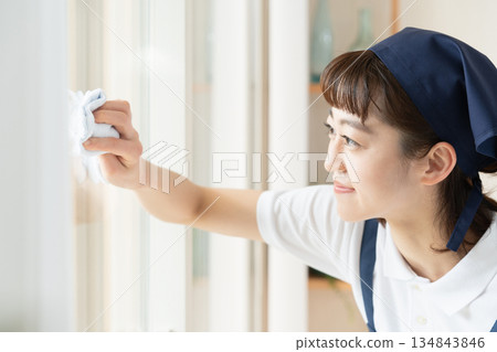 A housekeeping woman cleaning windows 134843846