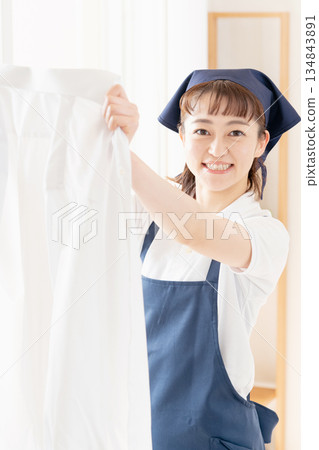 一位女傭正在晾衣物。 134843891