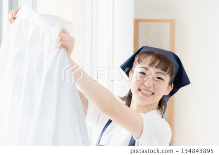 一位女傭正在晾衣物。 134843895