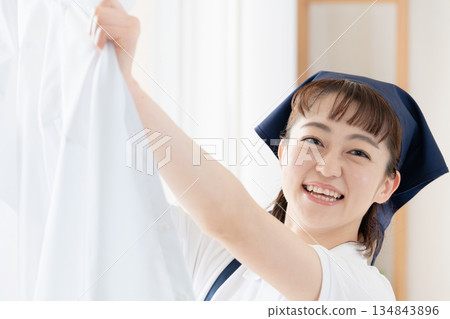 一位女傭正在晾衣物。 134843896