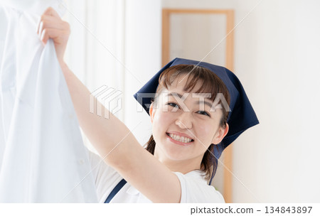 一位女傭正在晾衣物。 134843897