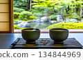 Steaming Matcha Tea Cups Overlooking a Lush Japanese Garden Thro 134844969